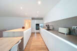 This modern kitchen boasts sleek, minimalist design with clean lines and ample counter space.