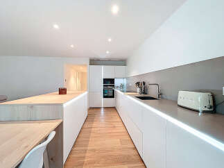 This modern kitchen boasts sleek, minimalist design with clean lines and ample counter space.
