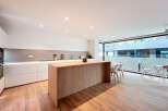 This modern kitchen boasts a sleek design with a large wooden island, perfect for meal preparation and entertaining.