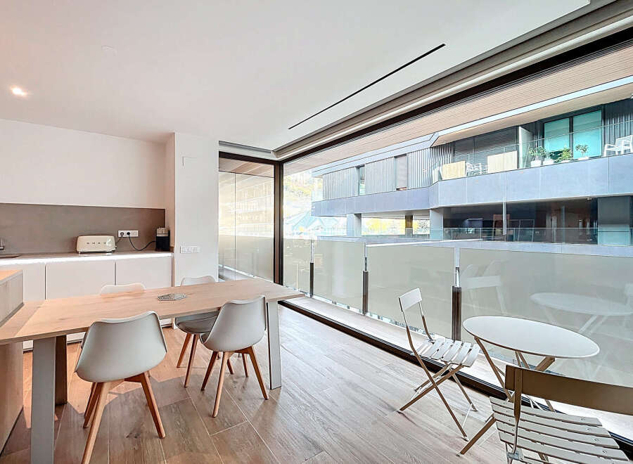 Experience modern living in this stylish property, featuring a bright and airy dining area with a sleek wooden table and contemporary chairs.