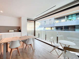 Experience modern living in this stylish property, featuring a bright and airy dining area with a sleek wooden table and contemporary chairs.