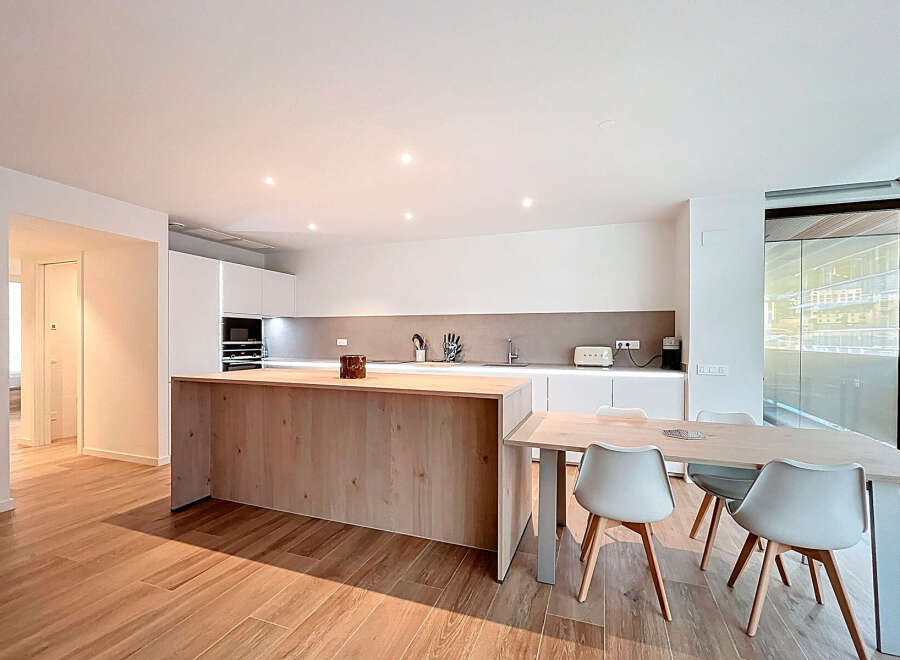 This modern kitchen boasts a sleek design with a large island and ample counter space, perfect for culinary enthusiasts.