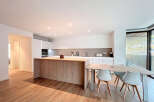 This modern kitchen boasts a sleek design with a large island and ample counter space, perfect for culinary enthusiasts.