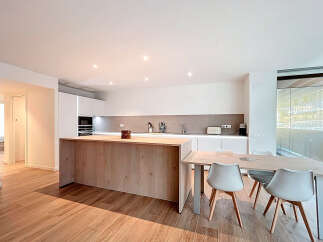 This modern kitchen boasts a sleek design with a large island and ample counter space, perfect for culinary enthusiasts.