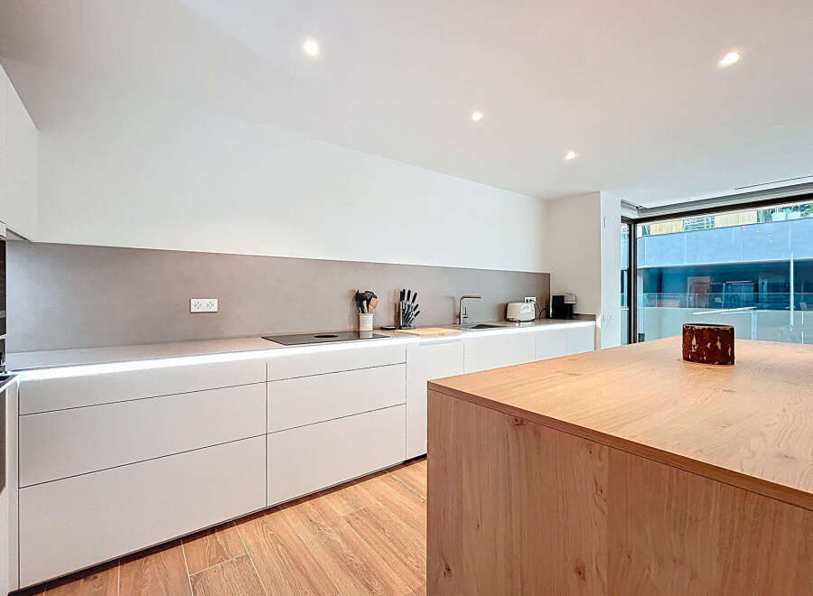 This modern kitchen boasts sleek, minimalist design with clean lines and ample storage.