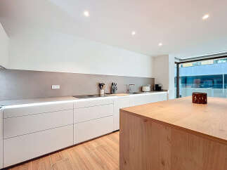 This modern kitchen boasts sleek, minimalist design with clean lines and ample storage.