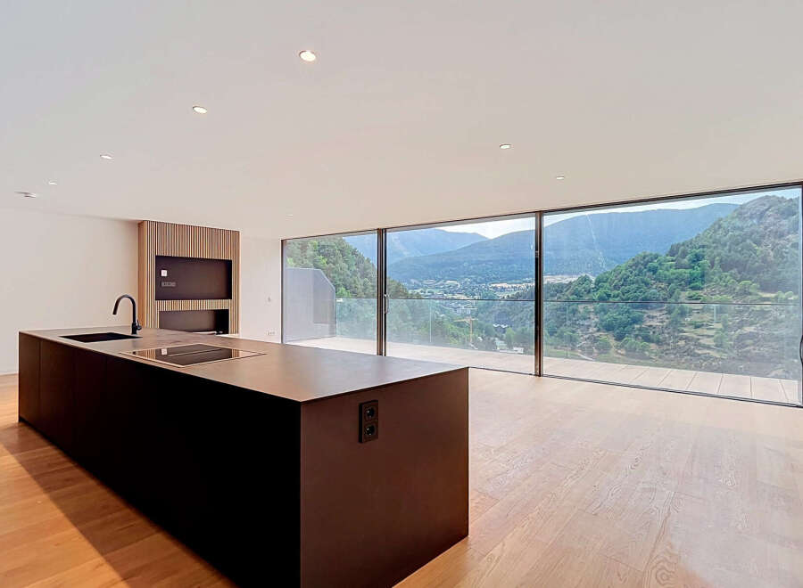 Experience modern living with this stunning open-concept kitchen and living area, boasting panoramic mountain views through expansive floor-to-ceiling windows.