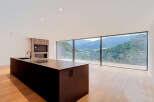Experience modern living with this stunning open-concept kitchen and living area, boasting panoramic mountain views through expansive floor-to-ceiling windows.