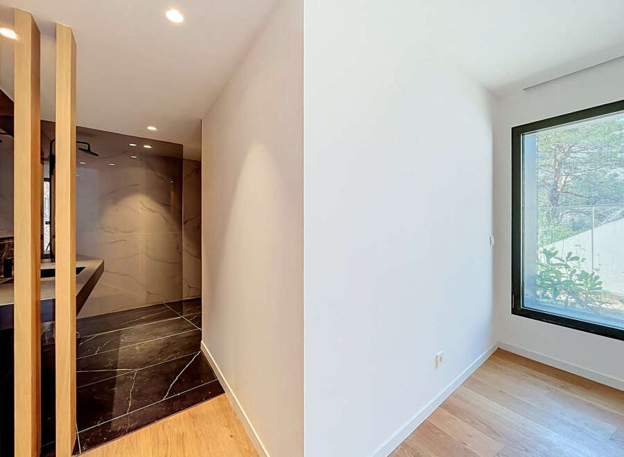Experience modern luxury in this stunning property featuring a sleek bathroom with marble accents and a spacious walk-in shower.