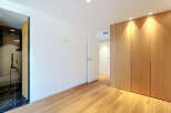 Experience modern living in this beautifully appointed room featuring a sleek, integrated wardrobe with natural wood finishes.