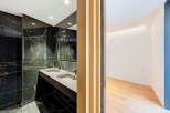 Experience modern luxury in this stunning bathroom featuring a sleek double vanity with a black marble backdrop.