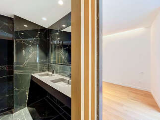 Experience modern luxury in this stunning bathroom featuring a sleek double vanity with a black marble backdrop.