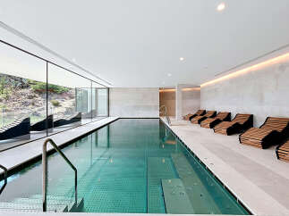 Experience ultimate relaxation in this luxurious indoor swimming pool area, featuring a stunning lap pool with crystal-clear water and integrated spa jets.