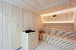 Experience ultimate relaxation in this beautifully crafted wooden sauna, featuring ample seating and modern heating elements.