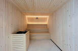 Experience ultimate relaxation in this modern sauna, featuring natural wood paneling and ambient lighting.