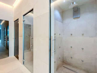 Experience ultimate relaxation in this luxurious spa-like bathroom featuring a spacious multi-jet shower enclosure.
