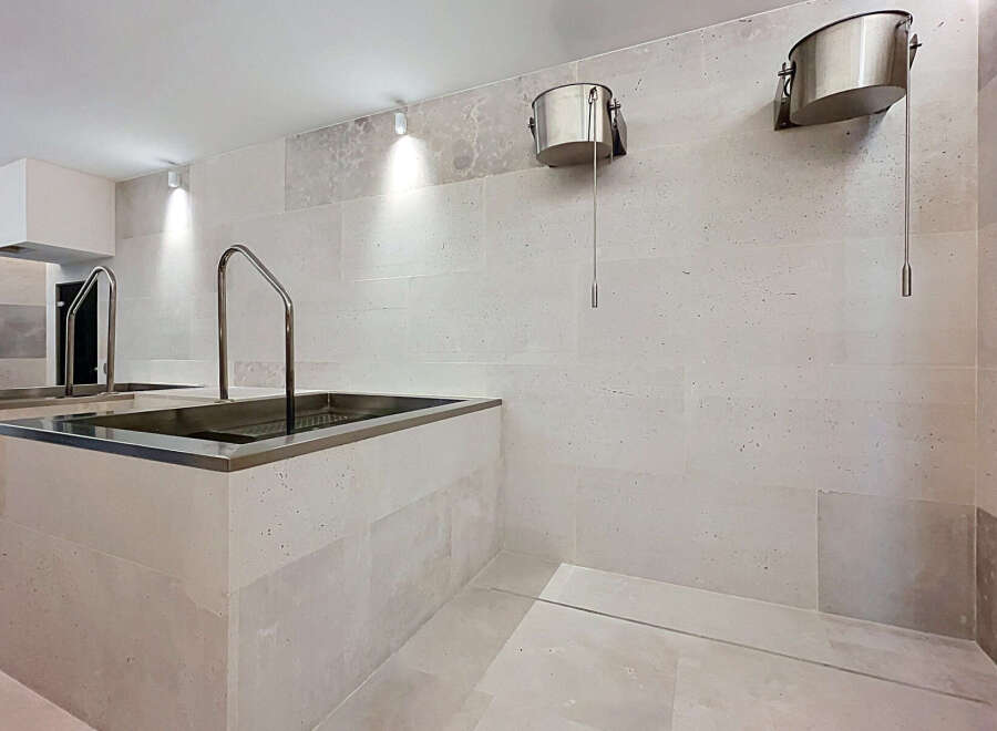 Experience ultimate relaxation in this spa-like bathroom featuring two built-in soaking tubs with chrome handles, perfect for unwinding.