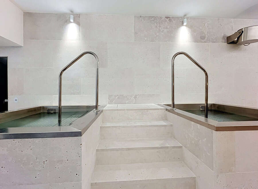 Experience ultimate relaxation in this spa-like bathroom featuring two built-in soaking tubs, perfect for unwinding.