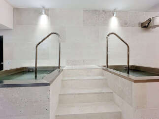 Experience ultimate relaxation in this spa-like bathroom featuring two built-in soaking tubs, perfect for unwinding.
