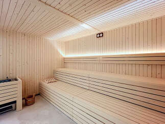 Experience ultimate relaxation in this luxurious sauna, featuring natural wood paneling and tiered seating for optimal comfort.