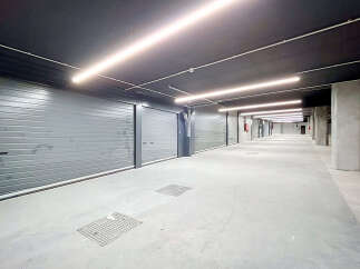 Discover this modern and secure underground parking garage, featuring individual roll-up doors for each unit.