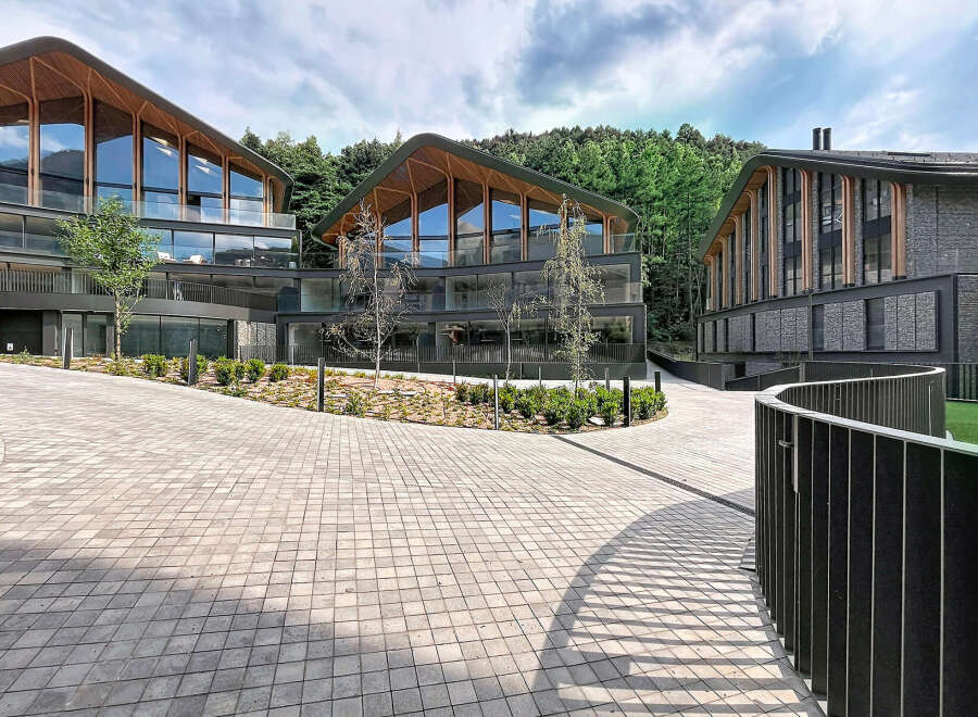 Discover modern architectural brilliance with these stunning multi-level buildings featuring unique, curved wooden-beamed roofs and expansive glass facades.