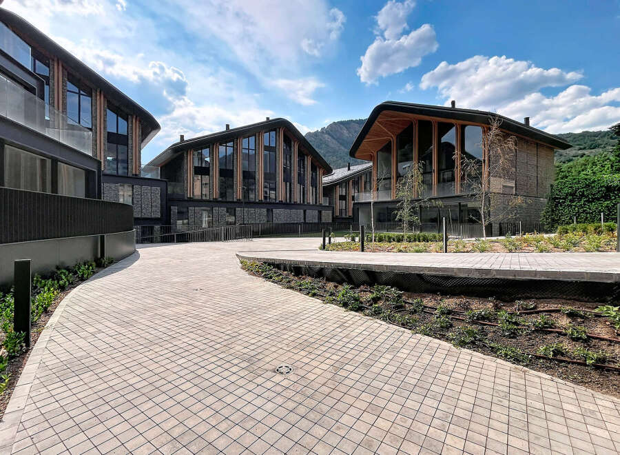 Discover modern living in this stunning architectural complex, featuring contemporary buildings with unique curved roofs and expansive glass facades.