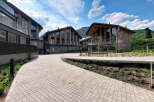 Discover modern living in this stunning architectural complex, featuring contemporary buildings with unique curved roofs and expansive glass facades.