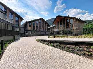 Discover modern living in this stunning architectural complex, featuring contemporary buildings with unique curved roofs and expansive glass facades.