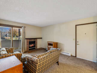Cozy up in this charming living room featuring a brick fireplace, perfect for those chilly evenings.