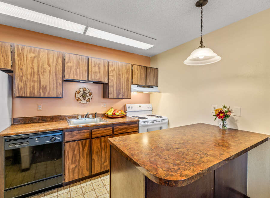 This charming kitchen boasts classic wooden cabinetry and a functional layout, perfect for everyday living.