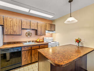 This charming kitchen boasts classic wooden cabinetry and a functional layout, perfect for everyday living.