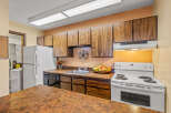 This charming kitchen boasts ample cabinet space and a functional layout, perfect for culinary enthusiasts.