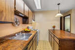 This charming kitchen features warm wood cabinetry and a spacious countertop, perfect for meal preparation and entertaining.
