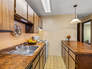 This charming kitchen features warm wood cabinetry and a spacious countertop, perfect for meal preparation and entertaining.