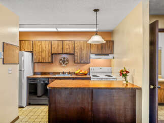 Step into this inviting kitchen, featuring warm wood cabinetry and a functional layout.
