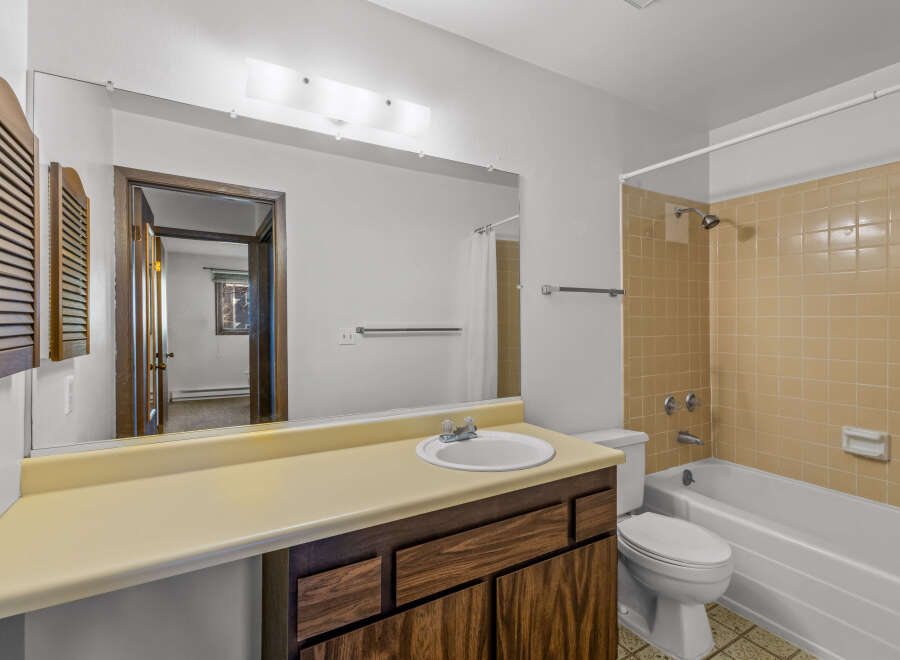 This bathroom features a classic design with a vanity, sink, and a mirror.