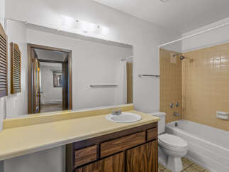 This bathroom features a classic design with a vanity, sink, and a mirror.