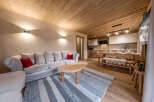 Experience the warmth of this inviting living space, featuring a cozy sofa adorned with vibrant red cushions.