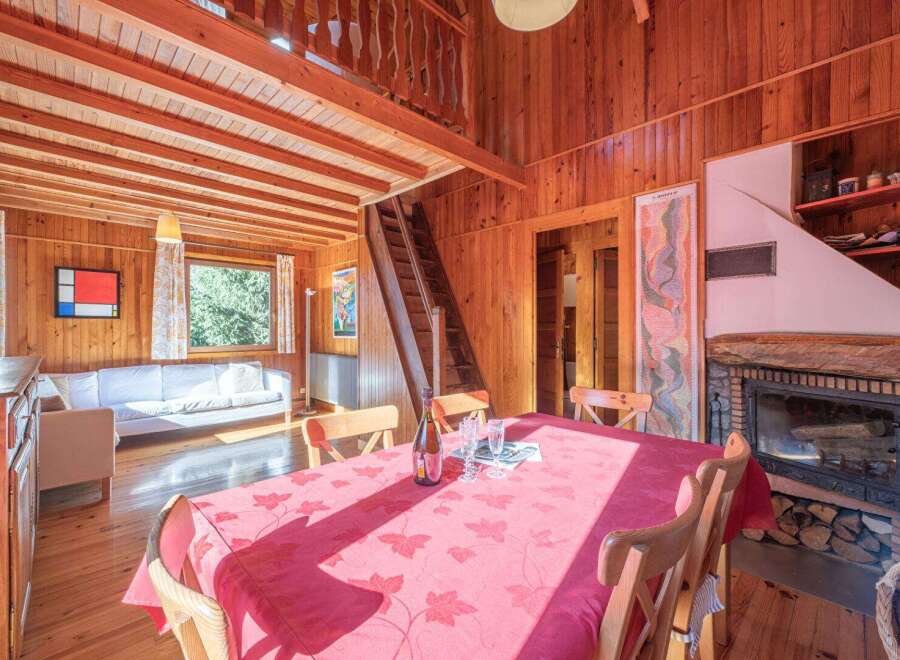 Step into this charming cabin retreat, featuring a cozy living space with a fireplace and a dining area perfect for gatherings.