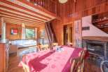 Step into this charming cabin retreat, featuring a cozy living space with a fireplace and a dining area perfect for gatherings.