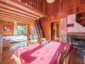 Step into this charming cabin retreat, featuring a cozy living space with a fireplace and a dining area perfect for gatherings.