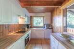 This charming kitchen boasts a warm and inviting atmosphere with its wooden accents and ample natural light.
