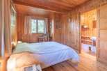 Step into this charming bedroom, featuring warm wooden paneling and a cozy ambiance.