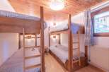 This charming bedroom features two sets of bunk beds, perfect for accommodating a family or a group of friends.