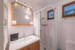 This charming bathroom features a modern shower, a stylish sink, and a large mirror.
