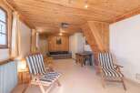 This charming property features a cozy living space with a wooden ceiling and walls, creating a warm and inviting atmosphere.