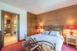 This charming bedroom boasts a rustic ambiance with its wooden paneling and cozy furnishings.
