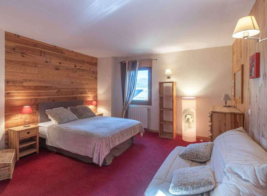 This cozy bedroom features a rustic wooden accent wall, creating a warm and inviting atmosphere.