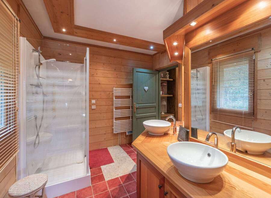 This stunning bathroom features a rustic design with wooden paneling and a modern shower.